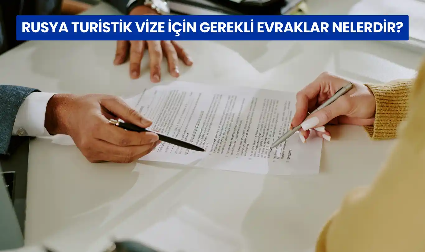 İki kişi masa üzerinde Rusya turistik vize evraklarını dolduruyor.